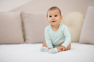 Such a happy little baby girl / Beautiful cute soft baby girl sitting on bed