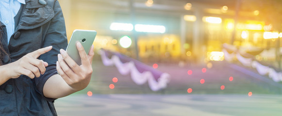 Woman hand using smartphone on bokeh background