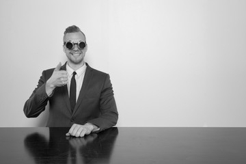 Wall Mural - Businessman sitting at office desk with binoculars