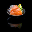 sashimi with tuna in a black plate. On a black background.