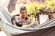 Happy couple resting on hammock with tablet