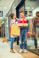 Couple with Christmas presents, gifts and shopping bags in a mall 