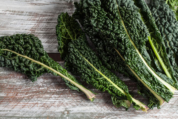 Above shot of organic lacinato kale on brown wood table above shot