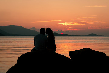 Romantic of couple love standing on the stone looking sunset at