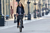 Fototapeta Miasto - Young woman on a bicycle.