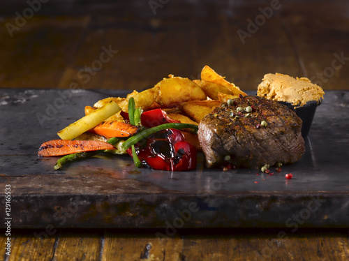 Zdjęcie XXL Stek z grilla wypełniony. Metalowy talerz. Drewniane tła.