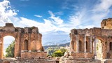 Fototapeta  - Ruins and columns of antique greek theater in Taormina and Etna Mount in the background. Sicily, Italy, Europe.