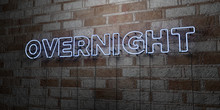OVERNIGHT - Glowing Neon Sign On Stonework Wall - 3D Rendered Royalty Free Stock Illustration.  Can Be Used For Online Banner Ads And Direct Mailers..