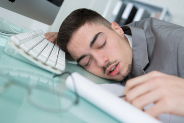 man tried from working and sleeping on working desk