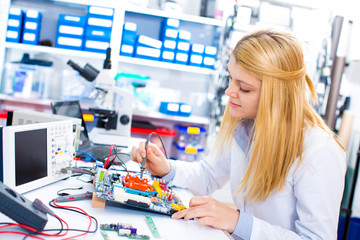 Canvas Print - Engineer working with circuits. A woman engineer 