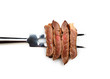 Piece of beef steak on meat fork on white  background