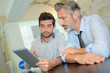 © auremar - business executive and co-worker using digital tablet in office