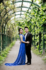 Wall Mural - Bride and groom on their wedding day outdoors. Chinese bride in a blue dress