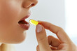 © puhhha - Close Up Of Beautiful Woman Taking Fish Oil Capsule In Mouth