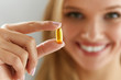 Beautiful Woman Holding Fish Oil Pill In Hand. Healthy Nutrition