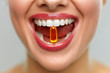 Beautiful Woman Mouth With Pill In Teeth. Girl Taking Vitamins