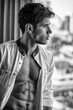 © theartofphoto - Sexy young man standing with shirt open on muscular chest in his bedroom next to window curtains