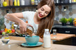 © rh2010 - Young woman making breakfast with granola and milk in the modern kitchen at home