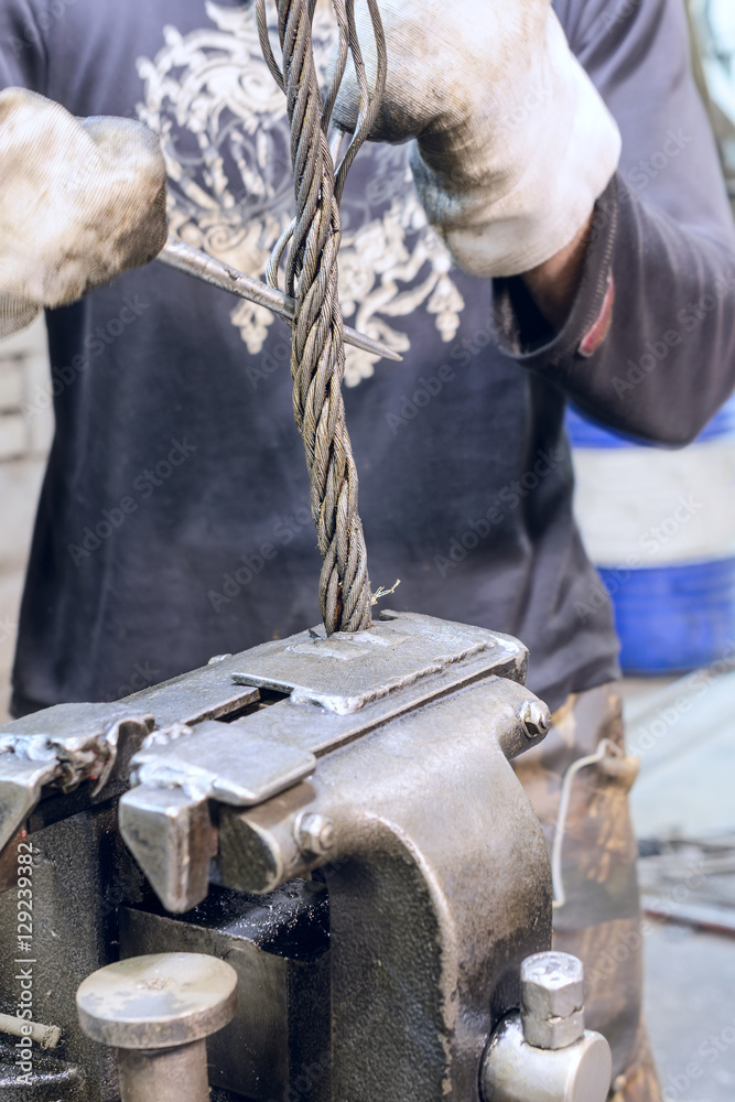 Worker braids end of the steel wire rope slings. Stock Photo | Adobe Stock