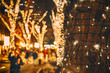 © EvgeniiAnd - Christmas lights on the tree. the Christmas lights on the tree trunk, closeup. blurred background city street with Christmas illuminations