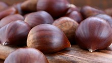 Close Up Macro Of Chestnuts On Wooden Table, Panning Right, HD Real Time.