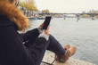Using cellphone with Paris background and Seine river.
