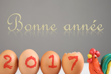 Inscription "Happy New Year" In French Language. Still Life With Eggs And Plasticine Cock. Rooster - A Symbol Of 2017 Year.