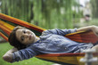 © PhotoAlto - Woman relaxing in hammock