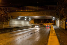 Gatubelysning Under Järnvägsbro Med Körandes Bilar På Kvällen