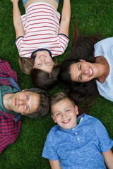 Wall Mural - Happy family lying on grass in park