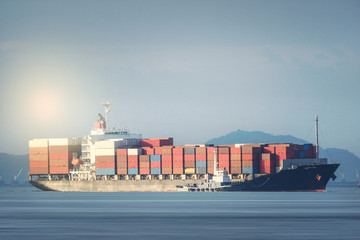 Logistics and transportation of International Container Cargo ship with tugboat in the ocean at sunset time, Freight Transportation, Shipping