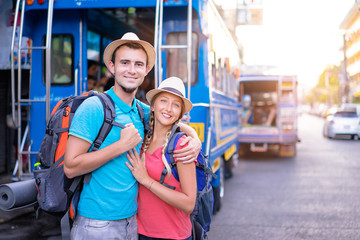 Wall Mural - Travel and tourism. Couple of backpackers walking together on asian street.