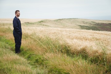 Poster - Thoughtful farmer standing in field