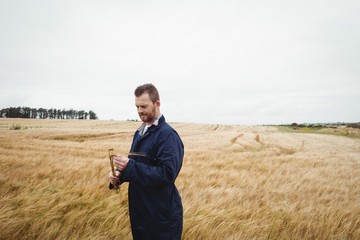 Poster - Farmer checking his crops in the field
