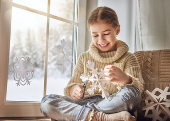 Wall Mural - Child makes paper snowflakes