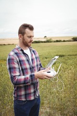 Poster - Farmer using agricultural device while examining in field