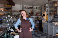 Portrait Of Smiling Woman Standing With Hands On Hip At Store