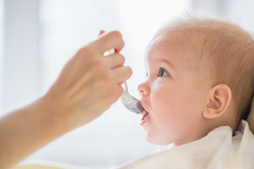 mother feeding her baby breast porridge day