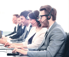 Wall Mural - Attractive young man working in a call center with his colleagues