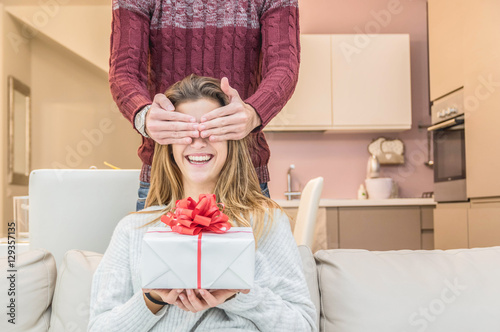 Fotografering Man keeps his girlfriend eyes covered while she giving a gift , romantic surpris