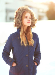 Winter fashion portrait woman wearing a jacket with hood on head