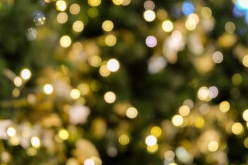 christmas tree bokeh light in green yellow golden color, holiday abstract background, blur defocused