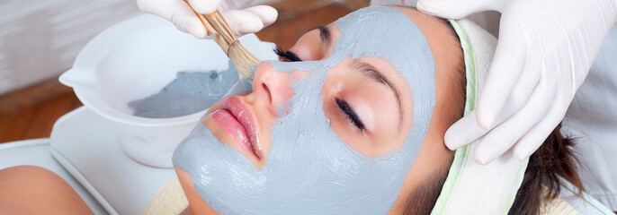 Girl with facial mask lying in beauty health spa center