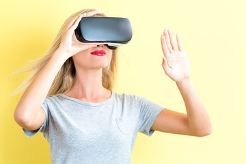 Wall Mural - Young woman using a virtual reality headset