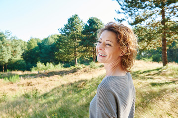 Wall Mural - Older woman smiling standing in nature