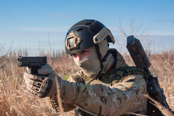 Wall Mural - airsoft soldier posing with pistol in fields