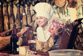 woman in uniform working with meat