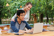 © Drobot Dean - Couple using laptop tohether in outdoor cafe