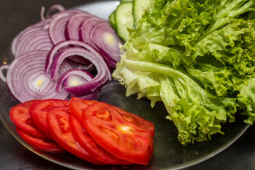 Wall Mural - Fresh sliced vegetables. Tomato, cucumber, onion and lettuce