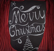 Merry Christmas hand drawn lettering with chalk on blackboard framed by red curtains. Elegant unique design with snowflakes and Christmas tree